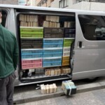 千代田区神田淡路町の古本出張買取で、ハイエースの側面からコンテナに入れた書籍を積載している様子