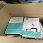 段ボール箱の中に入った健康法やヨガ・ピラティス関連の本