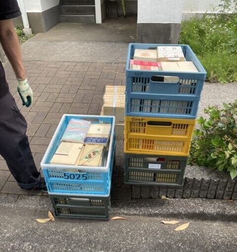 マンション前で思想・哲学関係の専門書が入ったカゴを搬出している様子。