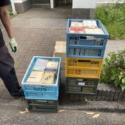 マンション前で思想・哲学関係の専門書が入ったカゴを搬出している様子。