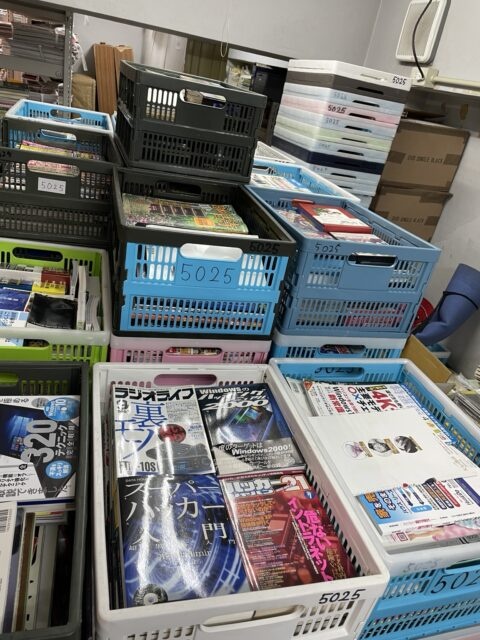 買取した本が入ったカゴが倉庫内に積み上げられている様子。