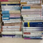 思想・哲学・人文・専門書が机の上に積み重ねられている様子。
