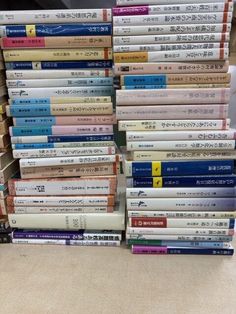 思想・哲学・人文・専門書が机の上に積み重ねられている様子。